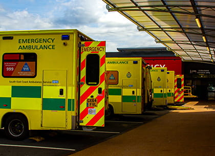 Row of ambulances lined up outside a hospital